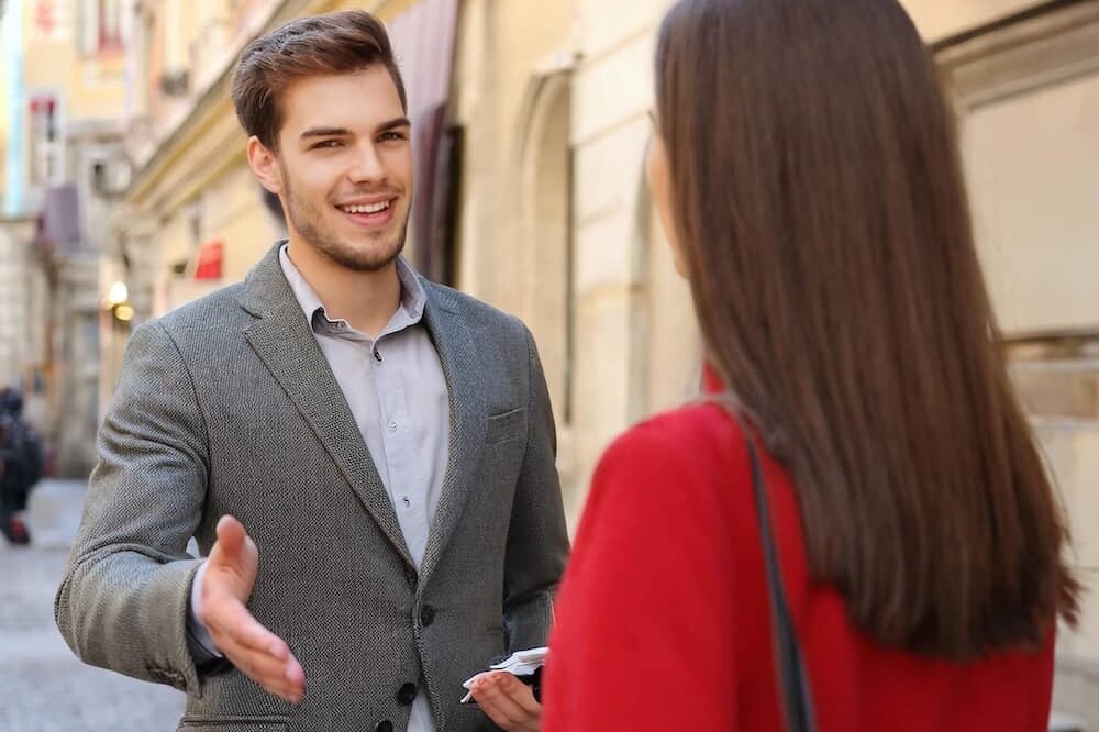man greeting a woman on the street