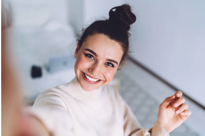 smiling woman taking a selfie from above