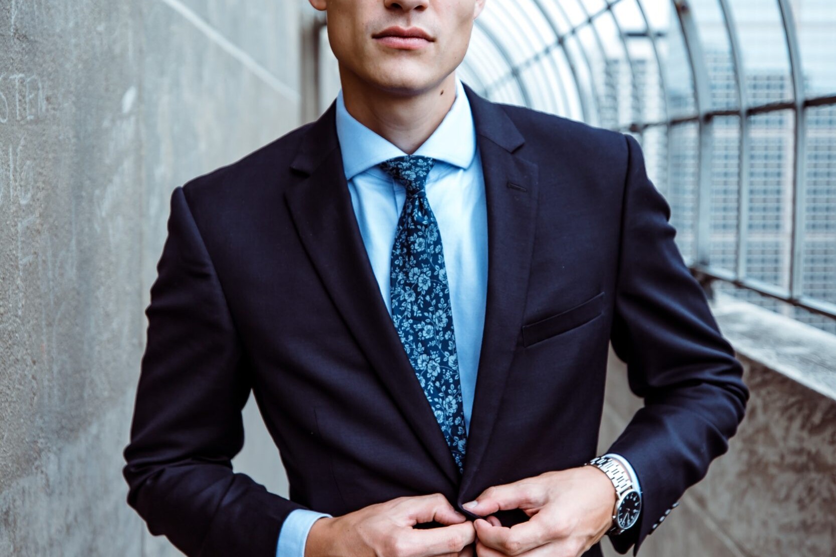handsome young man buttoning his suit jacket