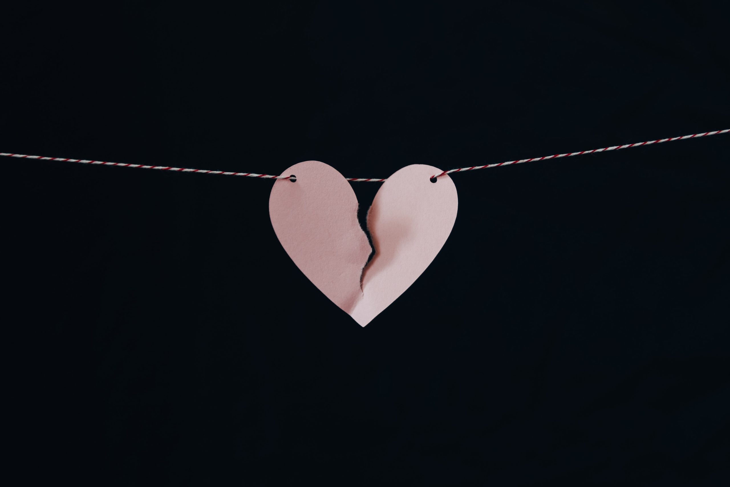 ripped pink paper heart on a string