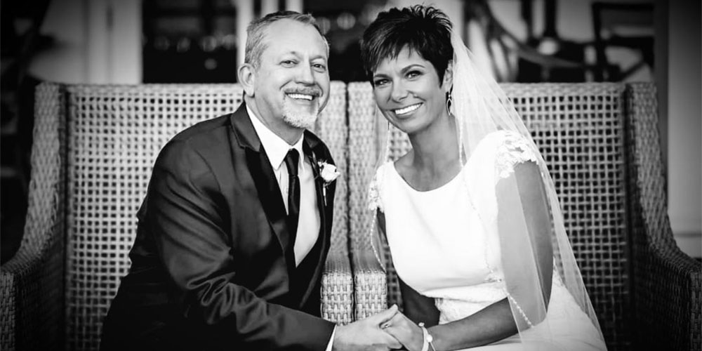 mature bride and groom sitting and holding hands