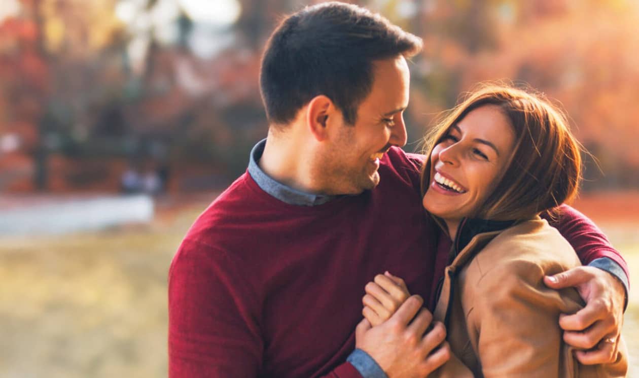 Couple in love hugging and enjoying at public park in autumn.